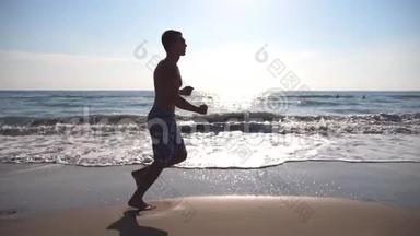 早上在海边跑步的运动青年。 在阳光明媚的日子里，运动员沿着海岸慢跑。 男运动员